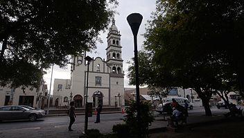 contenedores de basura apodaca calle de ciudad con iglesia de fondo